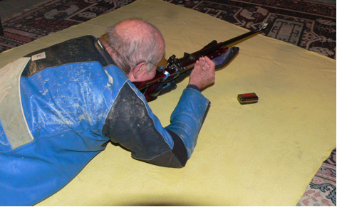 Fig 1. Showing the rifle leaned to the right in order to reach the loading port with the right elbow still on the firing point. This technique has major flaws, particularly with a full bore rifle. Even the slight recoil of the .22 rim fire will cause the sling to loosen even after just two, or three shots if you leave the rifle butt in the shoulder to reload. If this is not corrected, there will be a high incidence of shot loss on the score board. Not recommended!